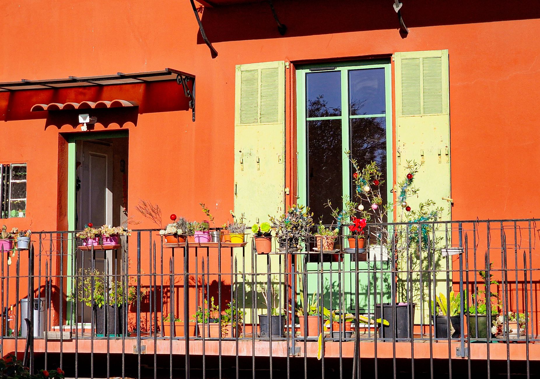 Colorful balcony with potted plants in Nice, Provence, exuding Mediterranean charm.