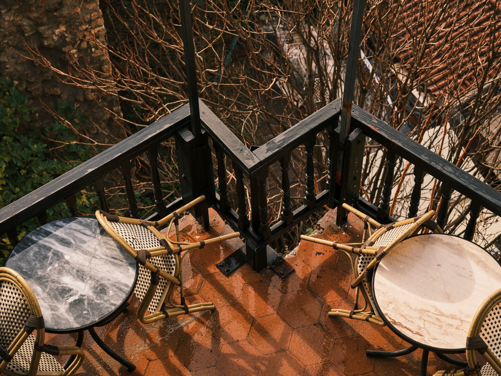 Charming balcony with chairs and round tables, perfect for an outdoor retreat.