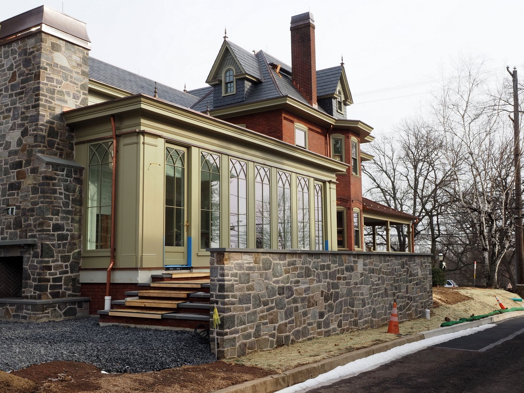 Renovated historic house in Doylestown, PA featuring a modern sunroom and stone architecture.